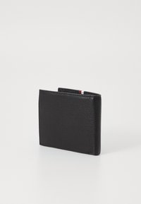 Portefeuille en cuir noir avec une surface texturée, design bi-fold et un petit accent de rayures rouges et bleues en haut.