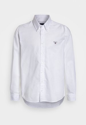Chemise blanche à manches longues avec col boutonné et petit logo GANT brodé sur la poitrine gauche.