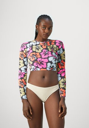 Long-sleeve crop top with a colorful hibiscus floral pattern on a black background; paired with textured light beige bikini briefs.