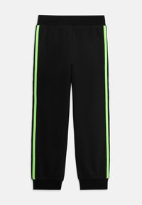 Zwarte sportbroek met een relaxte pasvorm, voorzien van neon groene zijstrepen en een elastische tailleband met ribgebreide manchetten bij de enkels.