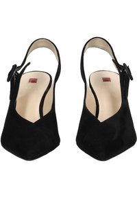Tacchi slingback in suede nera con punta affusolata, caratterizzati da una fibbia rotonda decorativa e solette color nude con un piccolo dettaglio rosso.