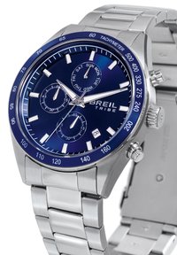 Montre en acier inoxydable argenté avec un cadran bleu, des index horaires blancs, des sous-cadrans chronographe et une lunette tachymétrique. Dotée d'un bracelet en métal.