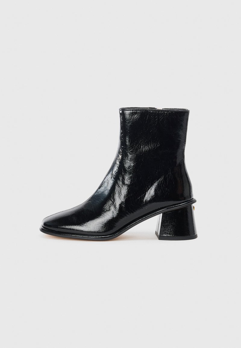 Botine negre din piele lucioasă, cu vârf ascuțit și un tocul bloc unic, având un detaliu circular accent.