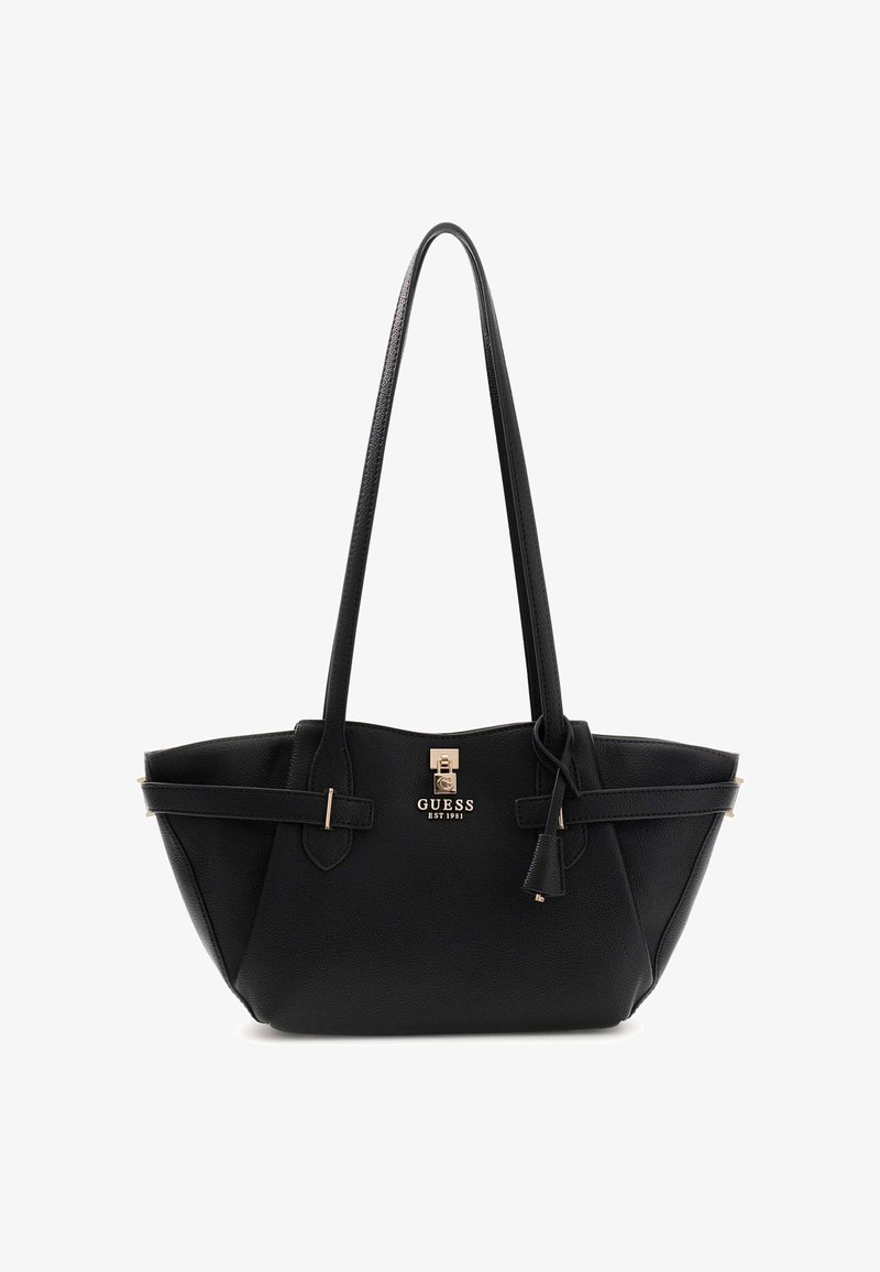 Sac à main noir Guess avec longues poignées, plaque logo dorée et sangles décoratives à boucle sur les côtés, en matériau texturé.