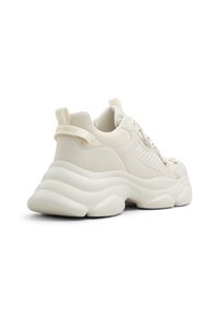 Baskets chunky en beige clair avec des panneaux texturés, un col rembourré et une semelle en mousse épaisse. Présente un tirant à l'arrière et un système de laçage.