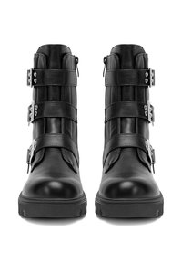 Para czarnych skórzanych botków za kostkę z trzema regulowanymi klamrami i bocznymi zamkami błyskawicznymi, pokazanych z przodu na białym tle.