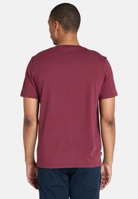 Burgundy bomull T-shirt med rund hals och korta ärmar, med rak passform och slät nederkant. Inga synliga logotyper eller mönster.