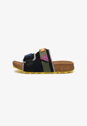 Sandale à bout ouvert avec une semelle en liège marron, une bande de roulement jaune, une tige en maille noire, des sangles réglables noires et vertes, et un petit patch violet sur le côté.
