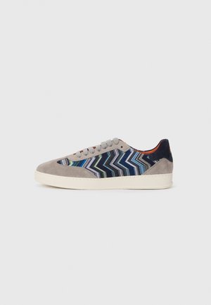 Suede and fabric sneaker in grey, navy, and multicolored zigzag pattern. Features a textured upper, round toe, and flat rubber sole.