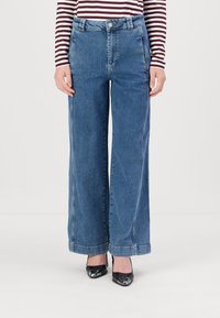 Jeans de mezclilla azul de pierna ancha con cintura alta, con cierre de botón, presillas para cinturón y bolsillo estándar. Acabado limpio en el dobladillo.