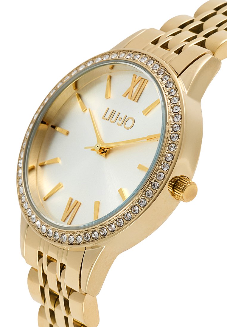 Orologio da polso dorato con quadrante blu chiaro, indici delle ore in oro e decorazioni in cristallo attorno alla lunetta. Bracciale in metallo con una finitura lucida.