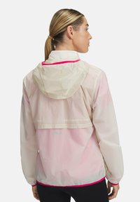 Leichte, hooded Jacke mit einem pinkfarbenen Verlauf, weißem Stoff, elastischen Bündchen und einem kontrastierenden pinken Saum an der Kapuze und am Saum.
