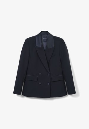 Blazer noir croisé avec revers en satin, deux poches plaquées frontales et boutons recouverts, posé à plat sur un fond blanc.