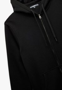 Sort zip-up hoodie med en rummelig frontlomme, snørebåndshætte og glat tekstur. Fremstillet af blødt, tykkere stof.