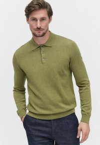 Oliivivihreä neulepusero, jossa on litteä kaulus, kolme nappia, pitkät hihat sekä ribbaus hihansuissa ja helmassa. Kankaan pinta näyttää pehmeältä ja teksturoidulta.