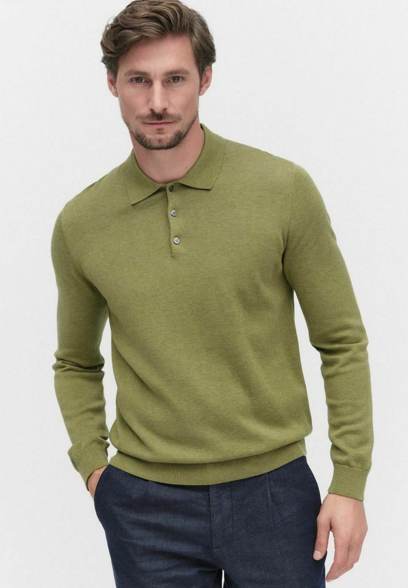 Oliivivihreä neulepusero, jossa on litteä kaulus, kolme nappia, pitkät hihat sekä ribbaus hihansuissa ja helmassa. Kankaan pinta näyttää pehmeältä ja teksturoidulta.