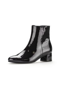 Bottines noires en cuir verni avec un bout pointu et un talon bloc épais. Surface lisse avec des détails de couture minimaux.