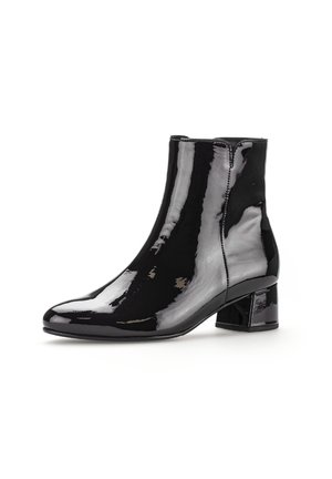 Bottines noires en cuir verni avec un bout pointu et un talon bloc épais. Surface lisse avec des détails de couture minimaux.