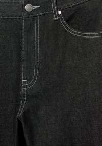 Jeans in denim nero con cuciture bianche a contrasto, un bottone metallico e un design classico a cinque tasche con una texture liscia.