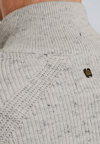 Kratak prikaz ovratnika svijetlosive pletene veste s teksturiranim uzorcima i malim crnim PME Legend logotipom na stražnjoj strani.