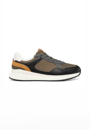 Scarpa da ginnastica bassa con pannelli neri, marroni, beige e bianchi, chiusura frontale con lacci e suola bianca spessa, vista di profilo su sfondo bianco.