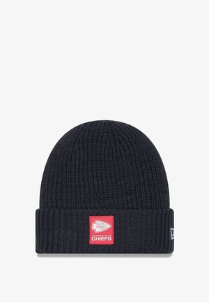 Navy-blaues gestricktes Beanie mit gerippter Textur. Auf der Vorderseite befindet sich ein rotes Patch mit dem Logo der Kansas City Chiefs. Mit umgeschlagenem Bündchen.