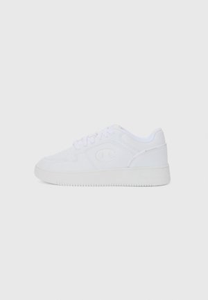 Hvite sneakers med en glat læroverdel, rund tå og flad gummisål. Har logo på siden og snøre-lukning.