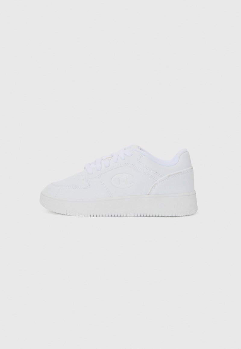 White sneakers with a smooth canvas upper, round toe, and flat rubber sole. Features logo on the side and lace-up closure.