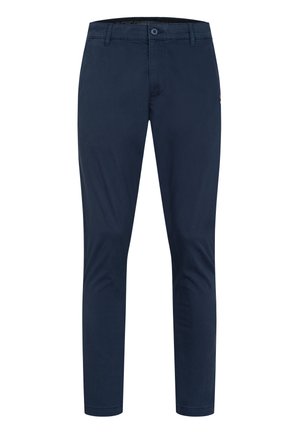 Granatowe spodnie w kroju slim fit z zapięciem na guzik i zamek, szlufkami na pasek i zwężanymi nogawkami.