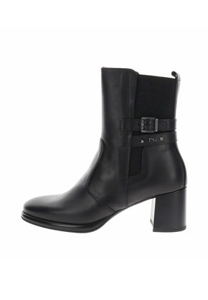 Stivaletto in pelle nera con tacco a blocco, cinturino laterale con fibbia e pannello elastico nella parte superiore per una calzata aderente.