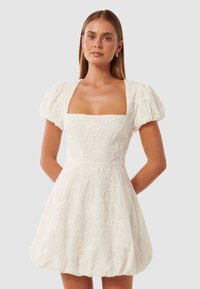Weißes Kleid mit Puffärmeln und rechteckigem Ausschnitt, verziert mit floralem Stickerei, einer taillierten Taille, die in einen weit schwingenden Rock übergeht.