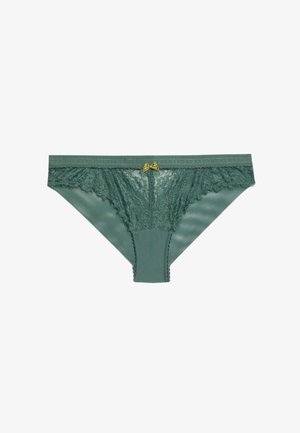 Tanga in pizzo verde e rete con una finitura liscia, caratterizzato da un delicato fiocco giallo al centro e bordi smerlati.