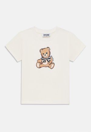 White cotton t-shirt featuring a brown teddy bear graphic with a black and white striped bow tie. Short sleeves and a classic crew neck design.