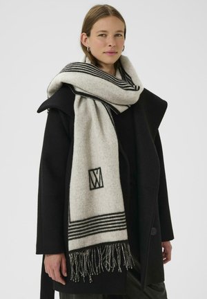 Sciarpa in lana con una combinazione di colori grigio e bianco, con righe nere e dettagli in frange. Logo monogramma mostrato sul tessuto.