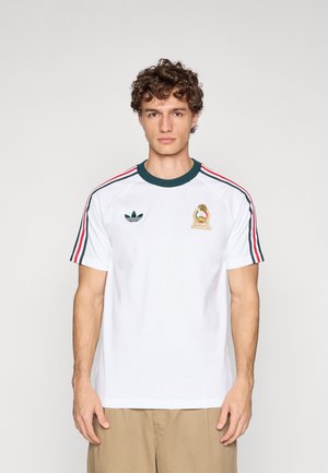 T-shirt bianca in cotone con collo a costine verde, maniche a righe rosse e verdi, e logo ricamato sul petto. Retro semplice.