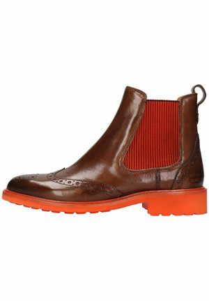 Bottines Chelsea en cuir marron avec des panneaux élastiques rouges sur les côtés et des semelles en caoutchouc orange vif, présentent des détails en brogue le long des orteils.