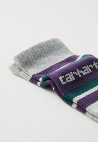 Multicolored socks featuring grey, purple, blue-green, and white stripes. Made of soft fabric with a ribbed top and logo detail.