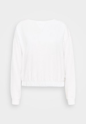 Bílá mikina s dlouhým rukávem a volným střihem, s ribbovanými manžetami a stahovacím pasem. Měkká látka s hladkým povrchem a výstřihem do V.