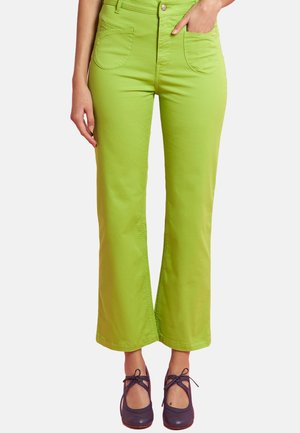 Green cotton blend wide-leg pants with front pockets and a button closure, paired with navy blue, rounded-toe shoes.