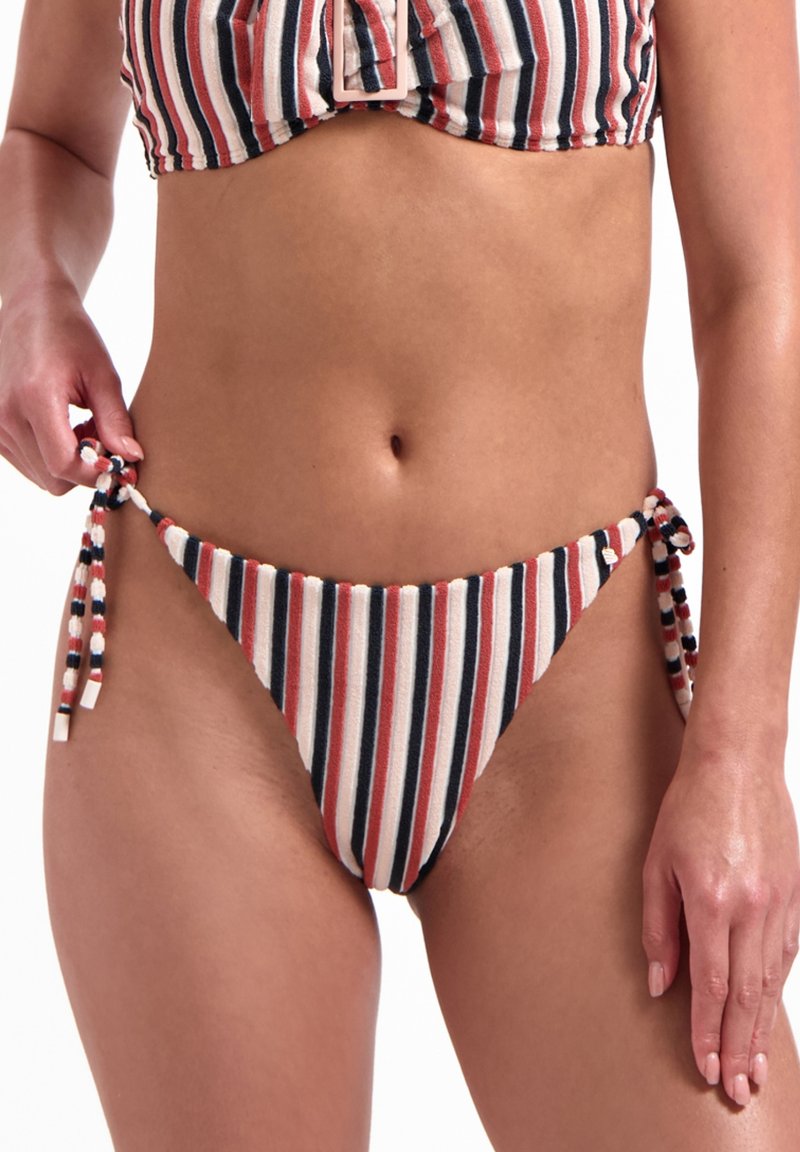 Bikini bottom a righe con lacci ai lati, nei colori rosso, blu navy e crema. Il tessuto sembra strutturato e ha una finitura morbida.