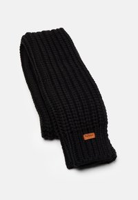 Fular negru tricotat din fir gros, cu o textură ribbed și o mică etichetă din piele de culoare maronie. Formă rectangulară, design minimalist.