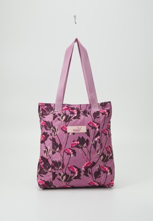 Lilla blomsterhandtaske med lyserøde og mørkelilla blomster, lange håndtag og et lille Puma-logo påsat midt foran.