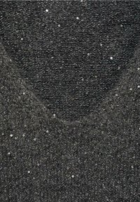 Gros plan d'un tissu tricoté gris foncé avec de petits sequins brillants dispersés dans toute la texture.