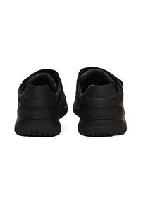 Zapatillas deportivas negras con un acabado de cuero liso, tacones redondeados, suelas texturizadas y detalles de costura mínimos en la parte trasera.