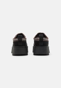 Scarpe nere in suede con suola spessa, bordo in tessuto intrecciato al colletto, linguetta sul tallone e suola in gomma testurizzata.