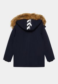 Abrigo de invierno azul marino con mangas largas, capucha con borde de piel sintética y texto blanco con flechas en el centro de la parte trasera de la capucha.