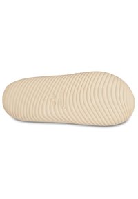 Lichtbeige Crocs schoenzool, met een getextureerd, golvend patroon en logo-afdruk, glad materiaal en een ronde neusvorm.