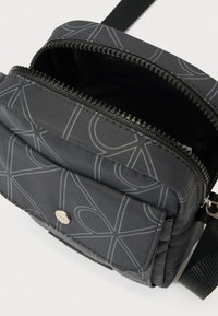 Must hall kõhukott hallide abstraktsete joonemustritega, lukuga põhiosa, esist taskut metallist trukiga ja reguleeritava rihmaga.