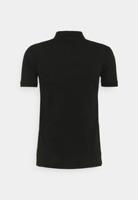 T-shirt polo noir avec des manches courtes, un col et un design épuré. Sans logos ni motifs visibles. Le matériau semble lisse et doux.