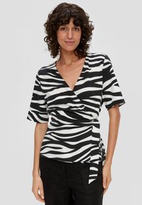 Zebra-print top met zwart-witte strepen, een v-halslijn, korte mouwen en een wikkelontwerp met een strikceintuur op de taille.